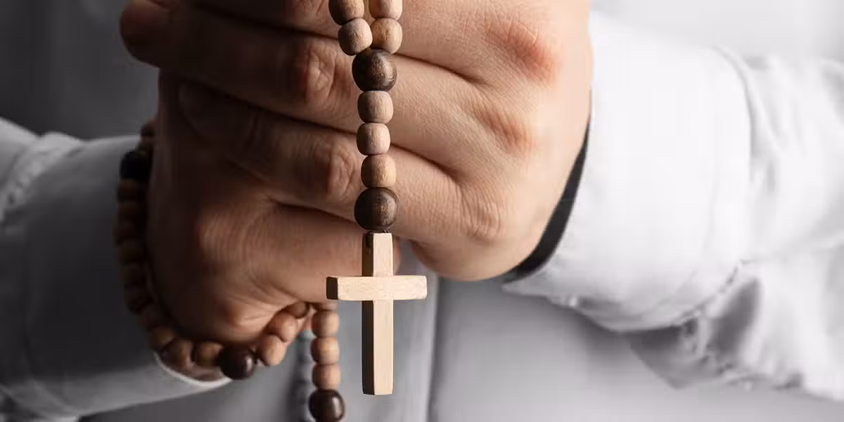 hands holding a rosary during prayer