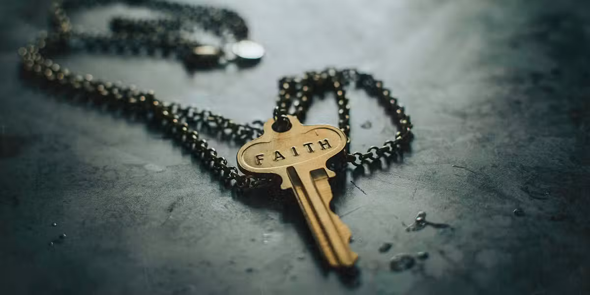 key on a chain with the words "Faith" imprinted