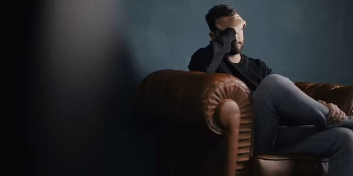man sitting stressed on a couch