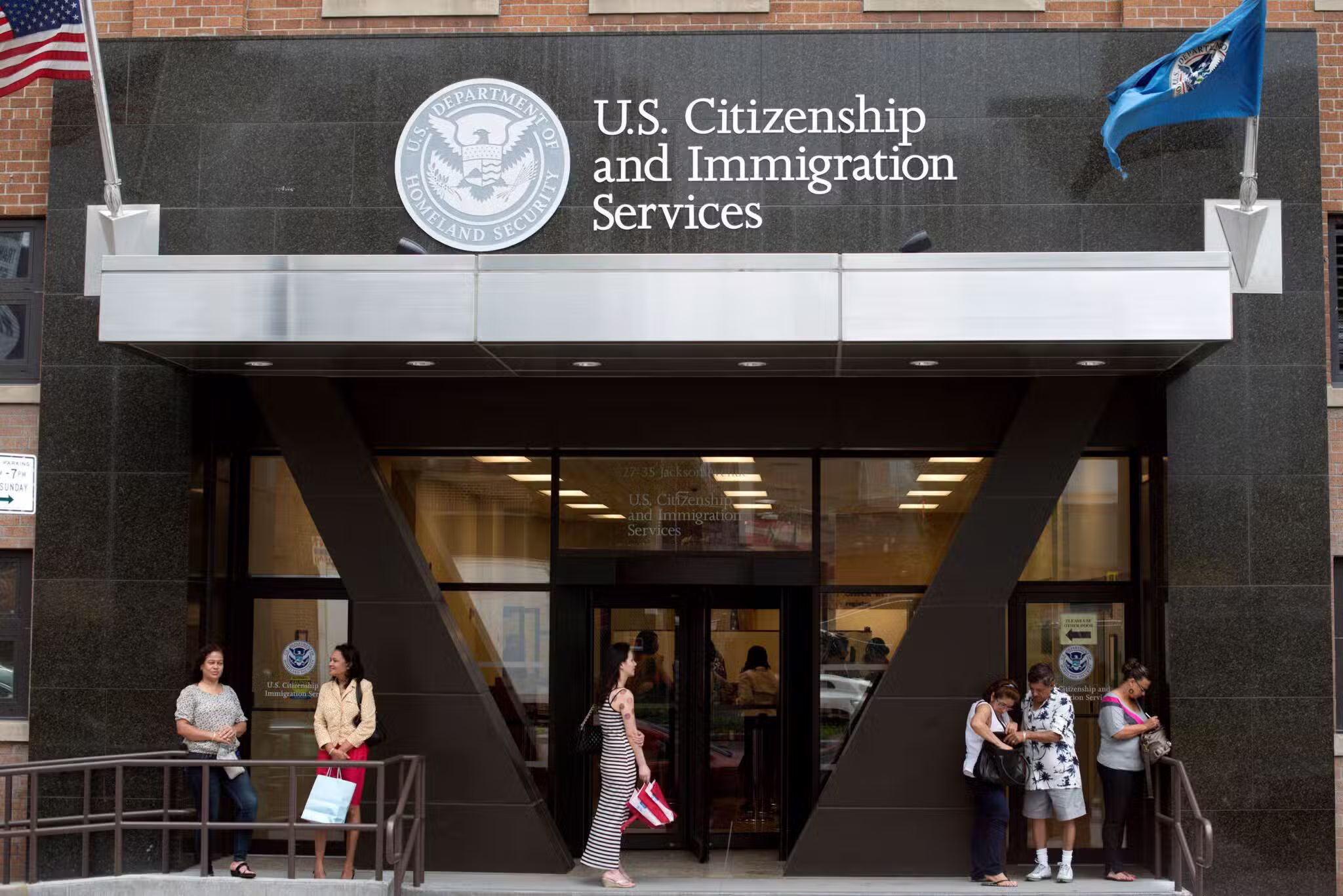 People are pictured in a file photo standing on the steps of the U.S. Citizenship and Immigration Services office in New York City.