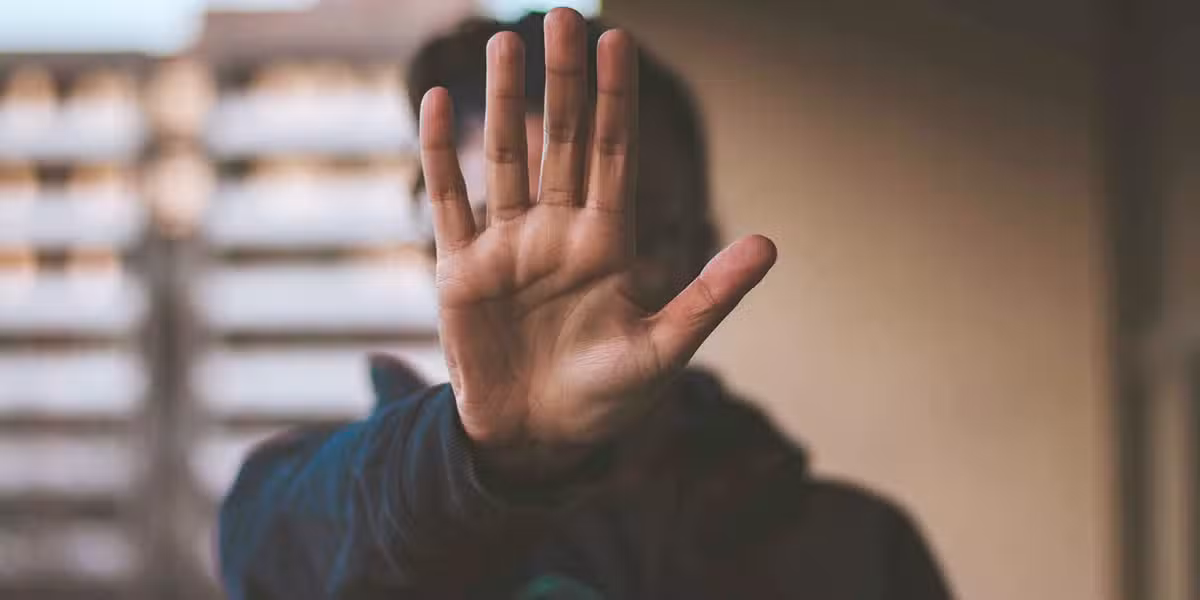 person raising hand as a symbol to stop
