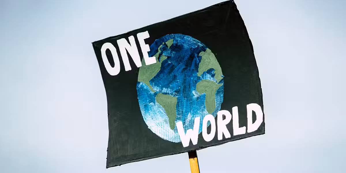 Protest sign "One World" calling for unity