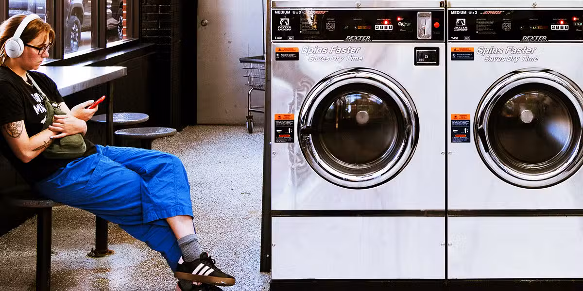 woman waiting for her laundry at a laundromat