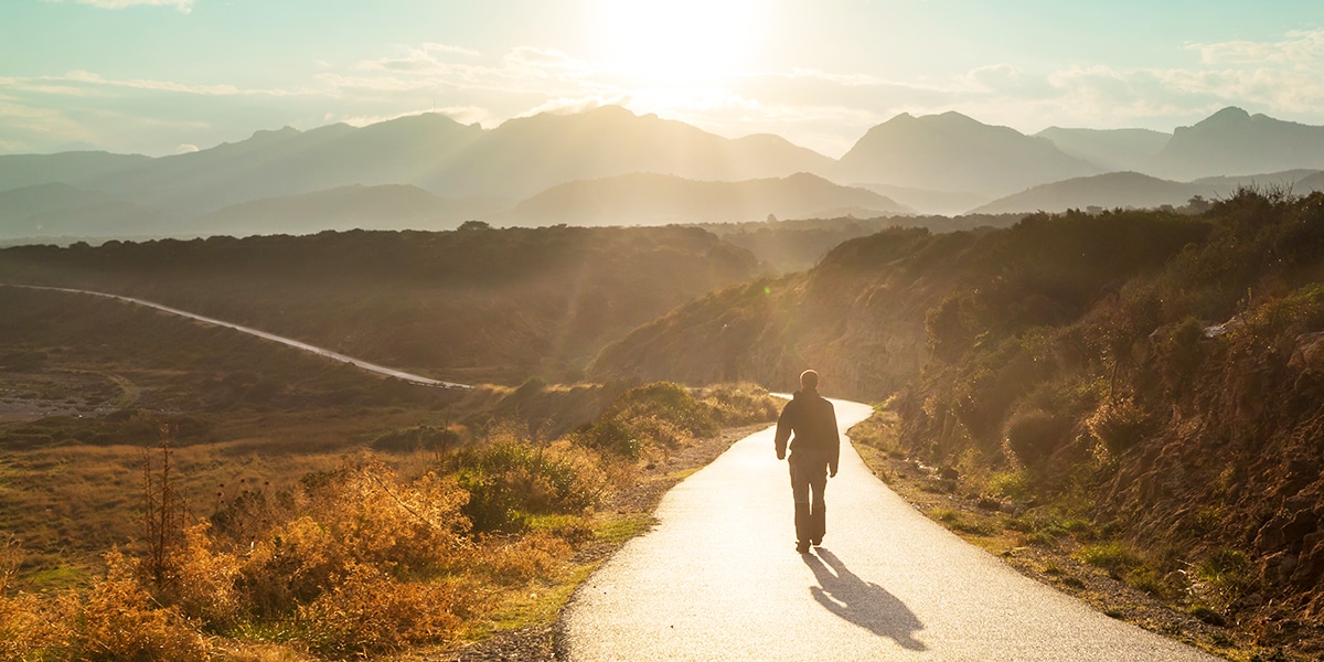man walking on a long path.