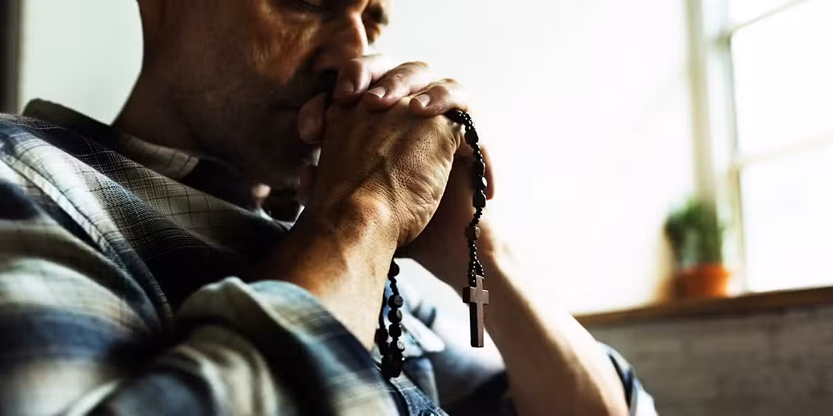 Man praying with a rosary