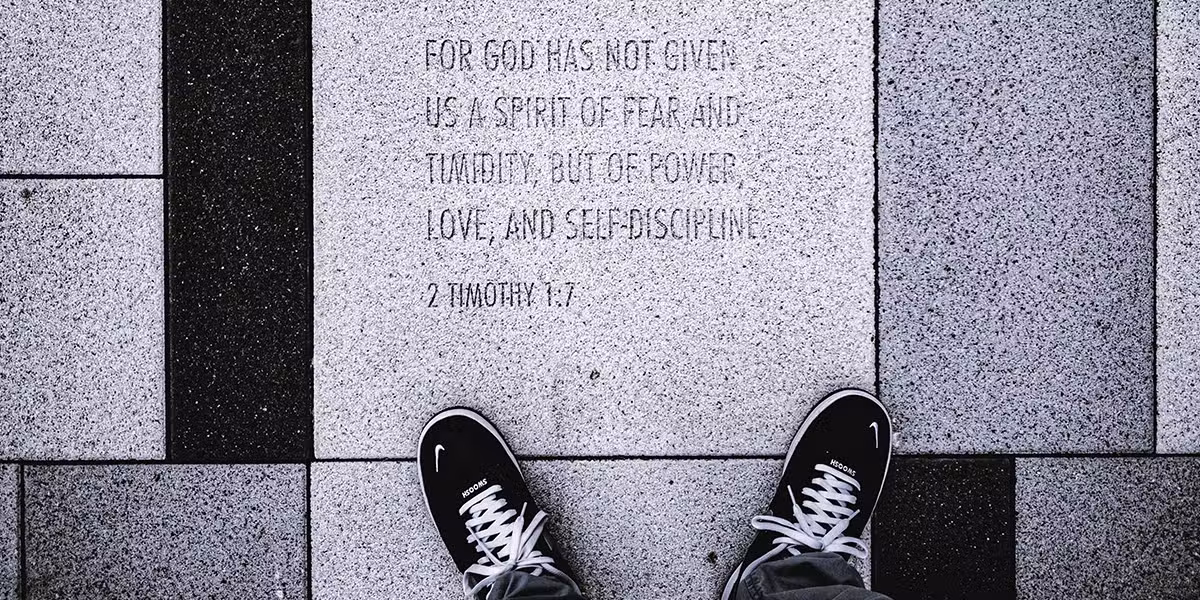 shoes and feet next to word scripture set in stone.