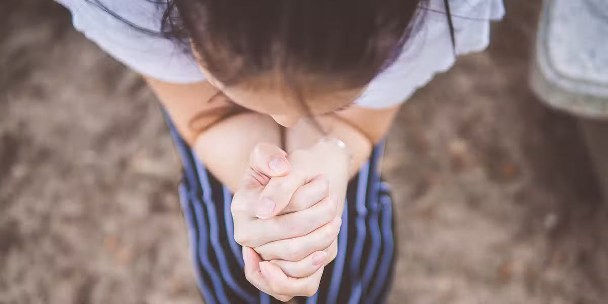 woman with folded hands praying.