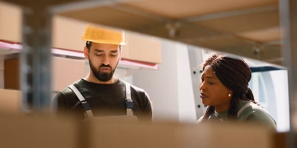 Coworkers talking while standing in a warehouse