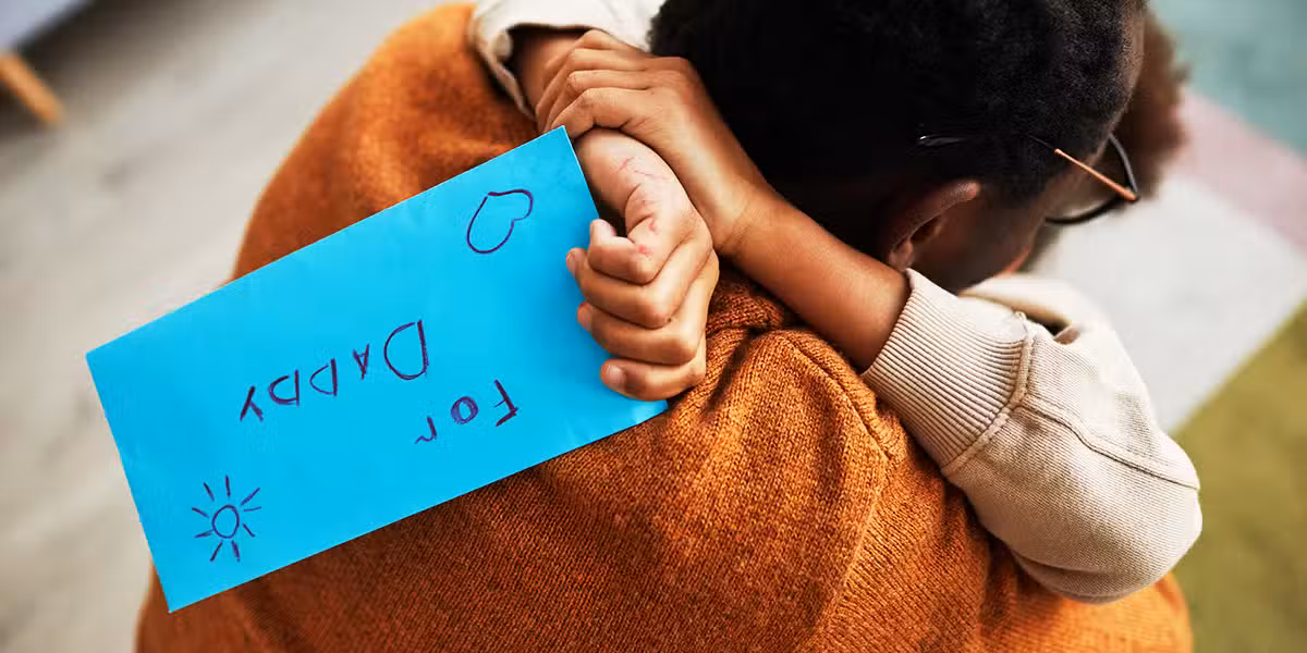daughter hugging father while holding a love note for daddy