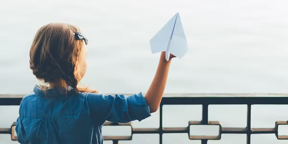 Girl enjoying a paper airplane