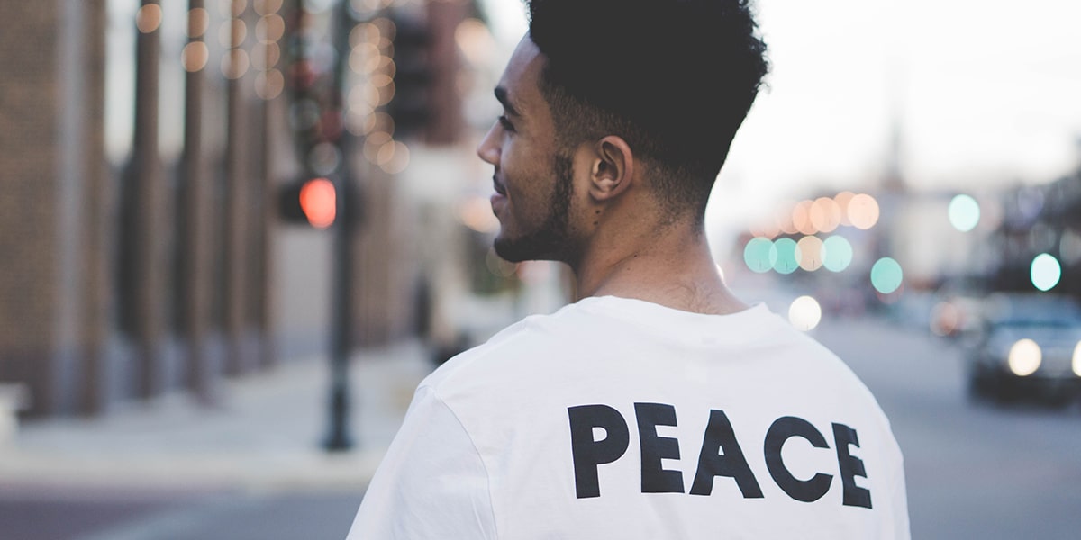 man wearing a t-shirt with the word Peace on the back.