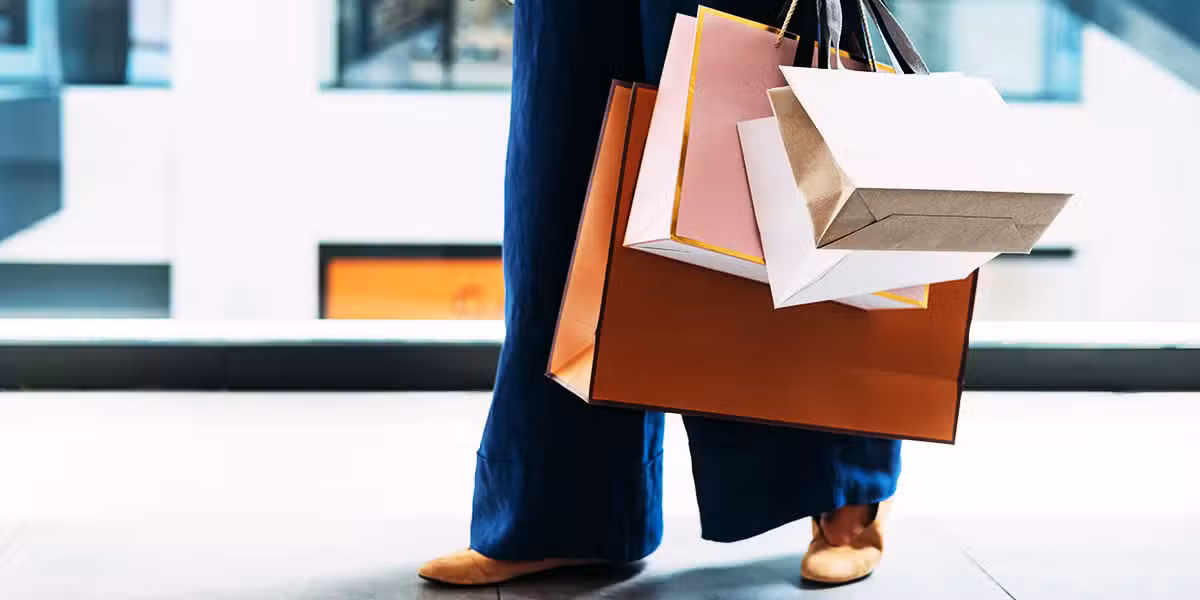person carrying a lot of shopping bags from the mall with expensive stuff.