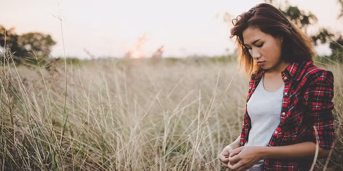hurting woman, praying and meditating in a field