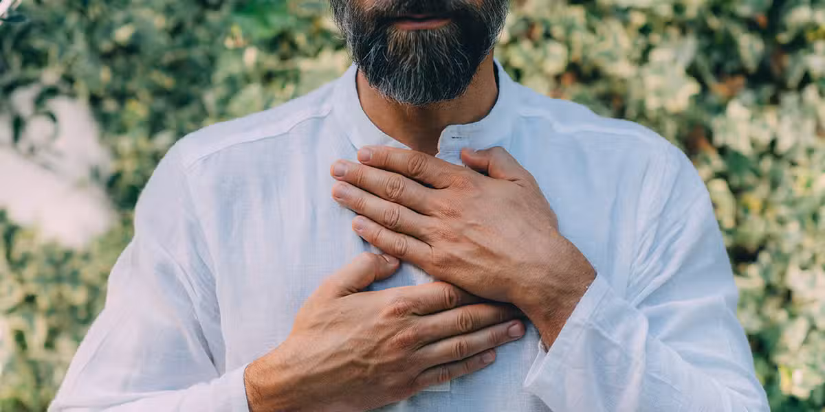 man putting his hands over his heart in gesture of gratefulness and thankfulness