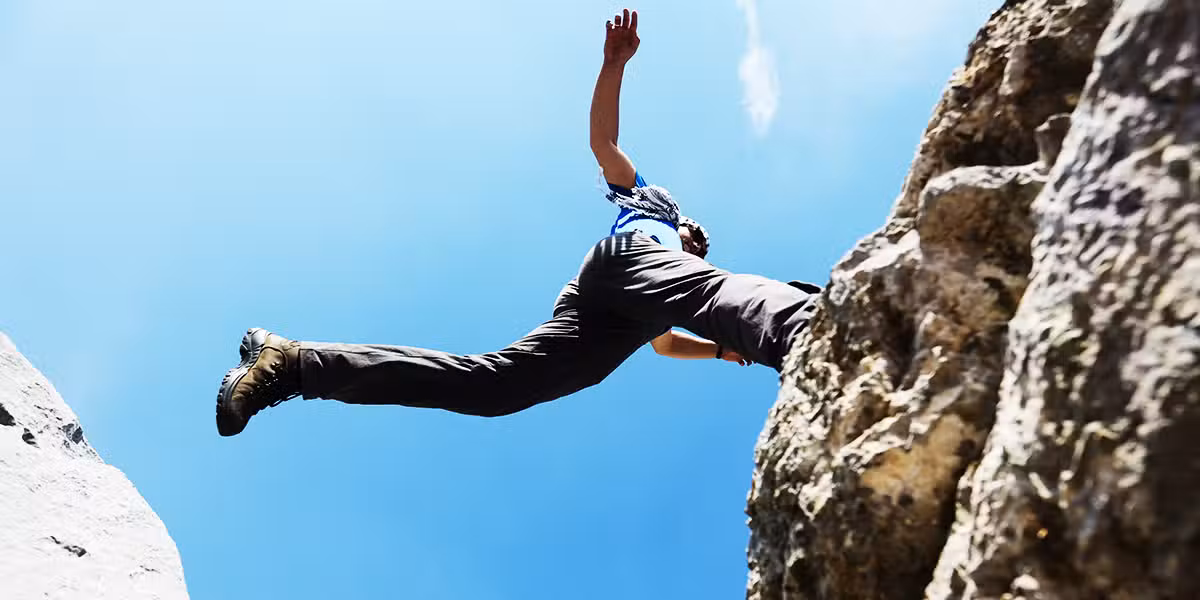 person jumping from rock to rock fearless