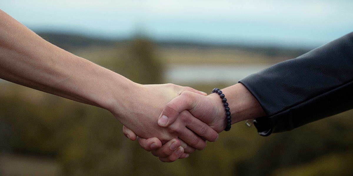 friends shaking hands | Photo by Malcolm Broström on Unsplash