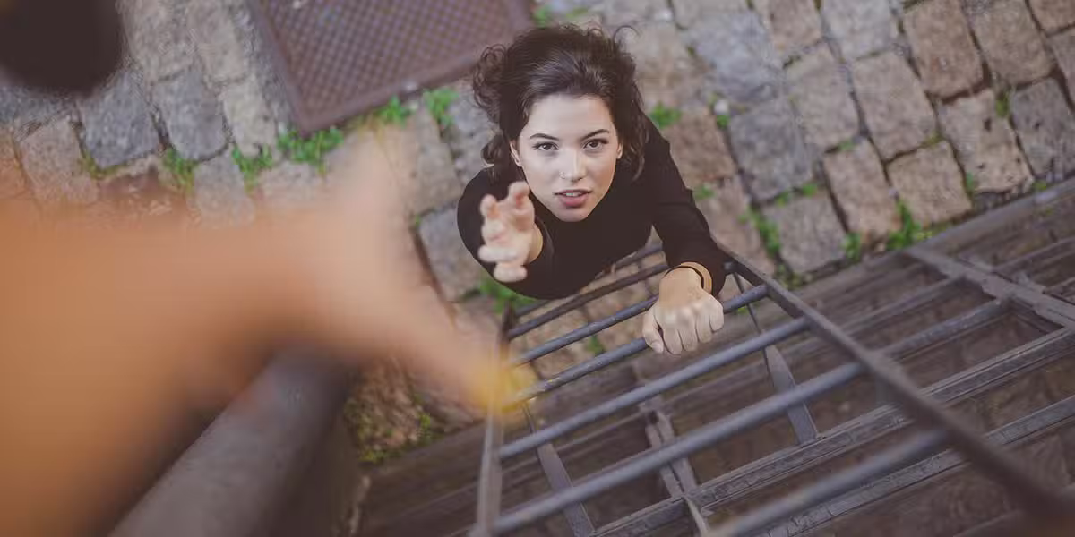 A woman reaching up for help