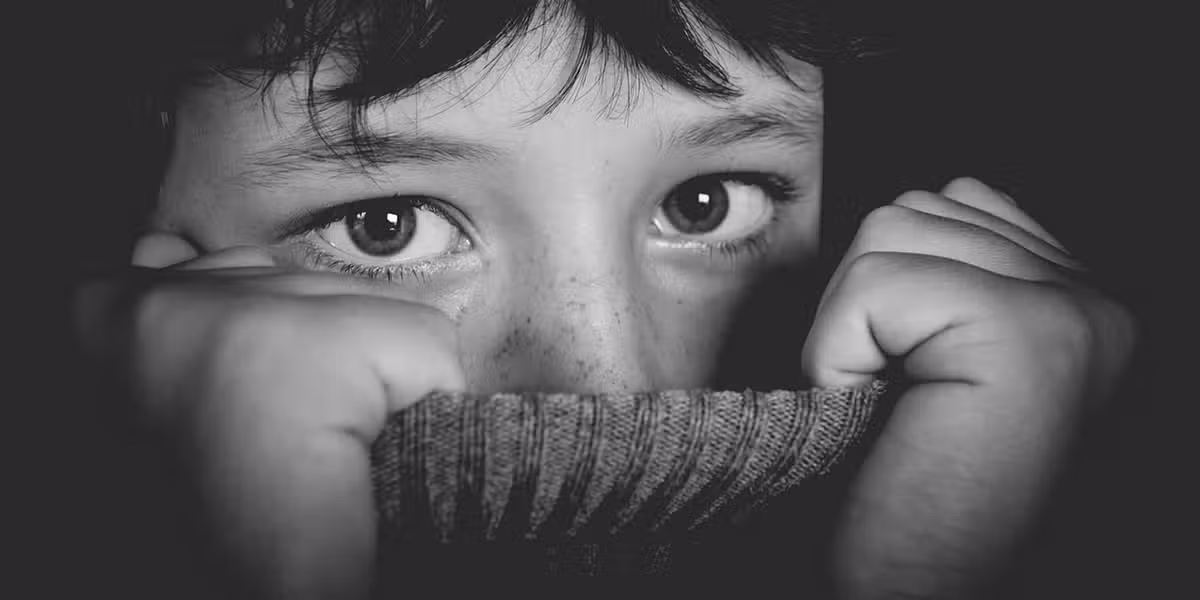 Girl peeking out from sweater pulled up around neck