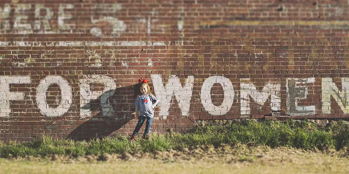 Young girl next to a wall | Photo by Katherine Hanlon on Unsplash