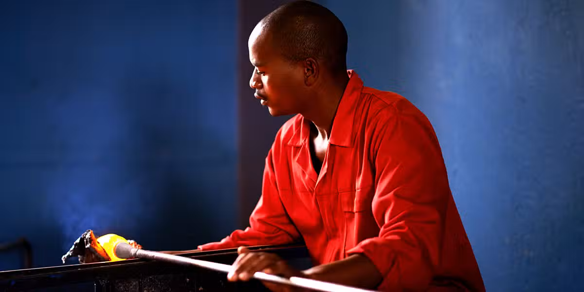 glassblower at work with glass and fire.