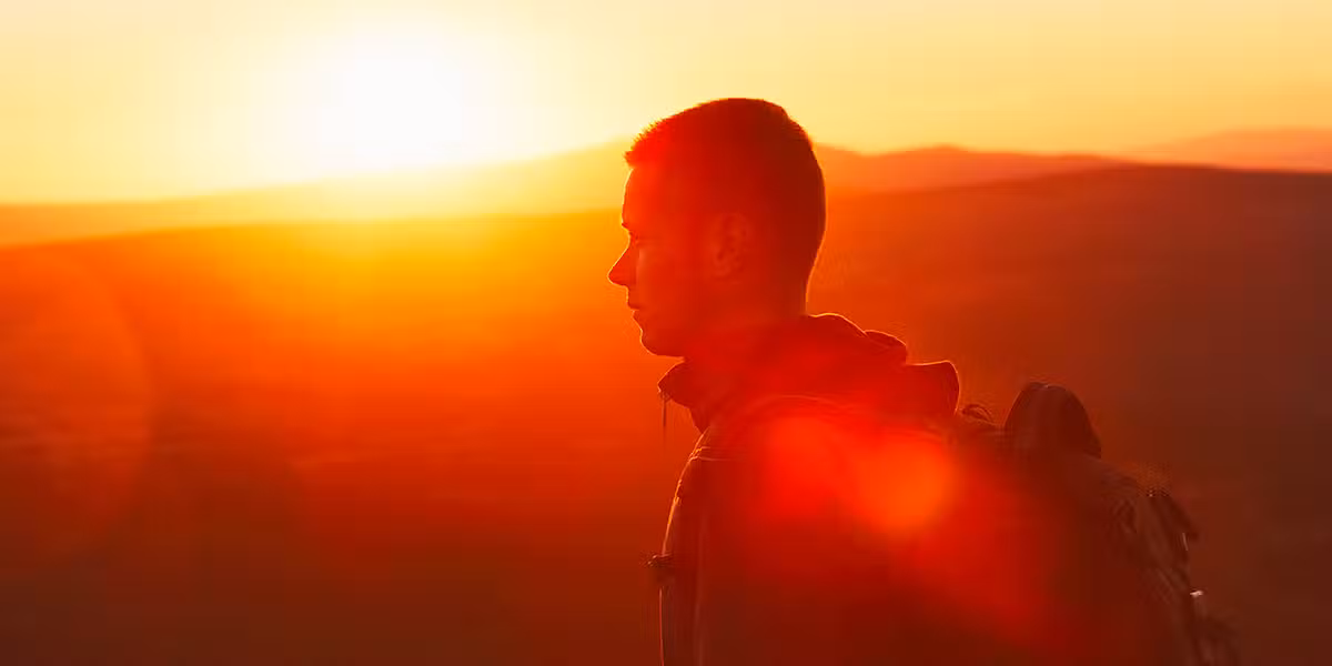 Young man bathed in sunlight walking