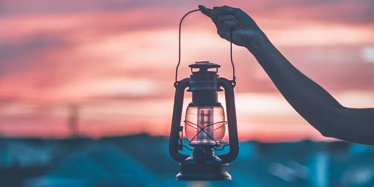 winning back the darkness; hand holding a lantern in the early morning; Thought Catalog/Unsplash