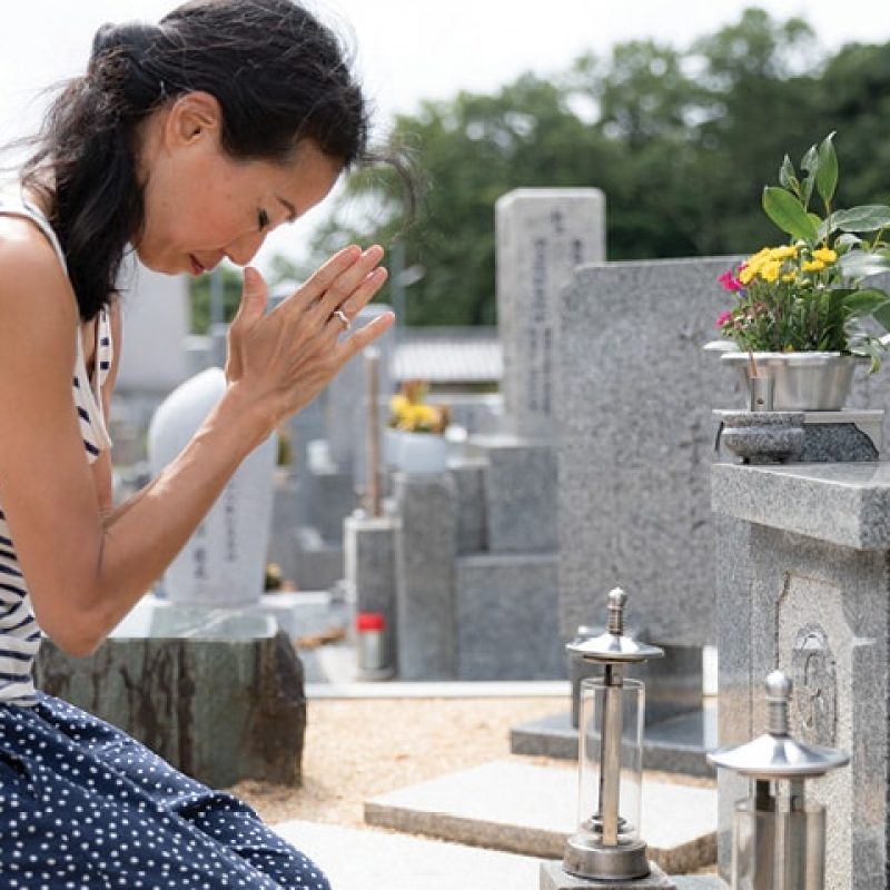 Person that appears to be praying next to a grave
