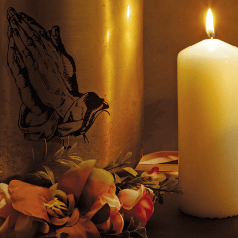 Candles and flowers next to an urn