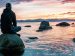 embrace silence and solitude; man sitting on a rock in the water, watching a sunset; Keegan Houser/Unsplash