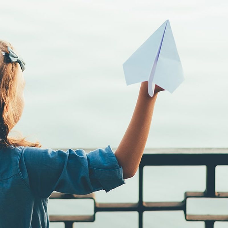 Girl enjoying a paper airplane