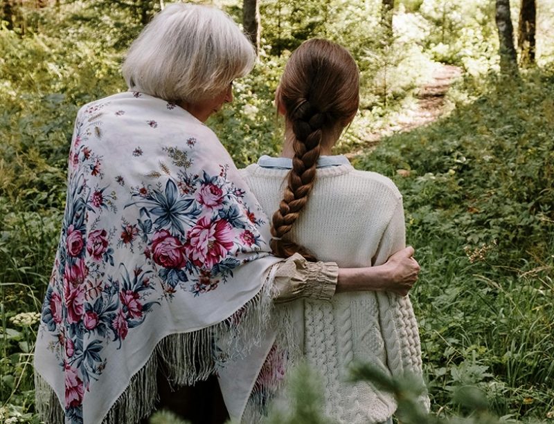 grandmother walking with granddaughter through a field