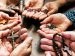 group of people in a circle holding rosaries and praying