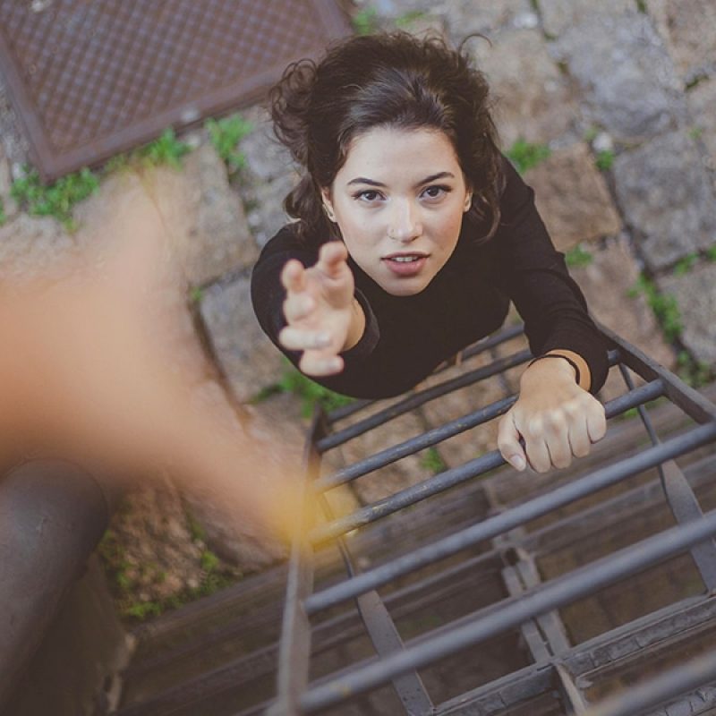 A woman reaching up for help