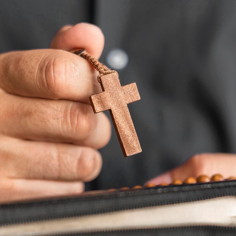 hand holding rosary during prayer