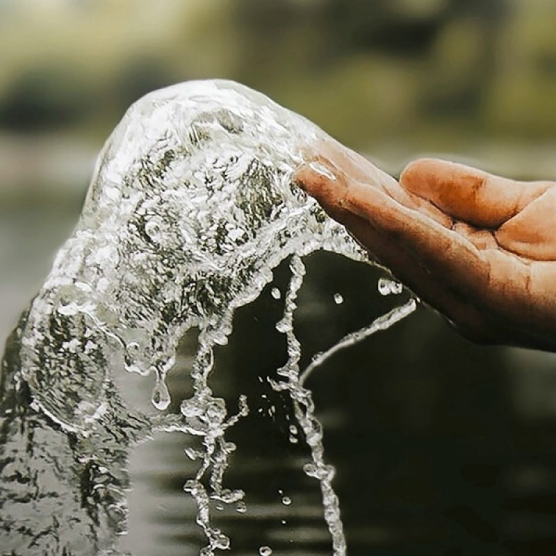 hand splashing water from a river