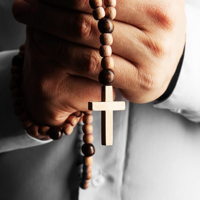 A person praying with a rosary