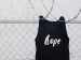 shirt with the word hope printed on it hanging on a fence.