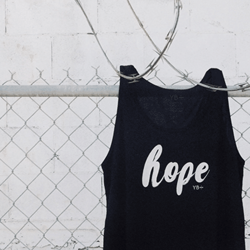 shirt with the word hope printed on it hanging on a fence.