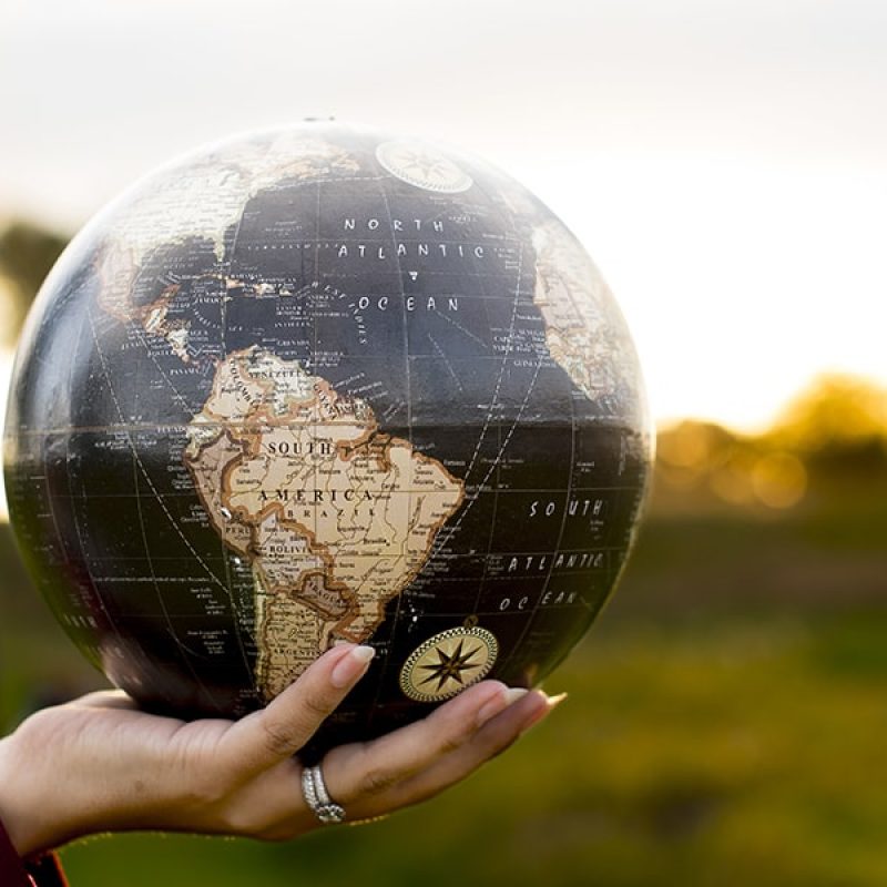 in God's hands, hand holding a globe.
