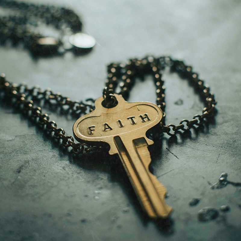 key on a chain with the words "Faith" imprinted