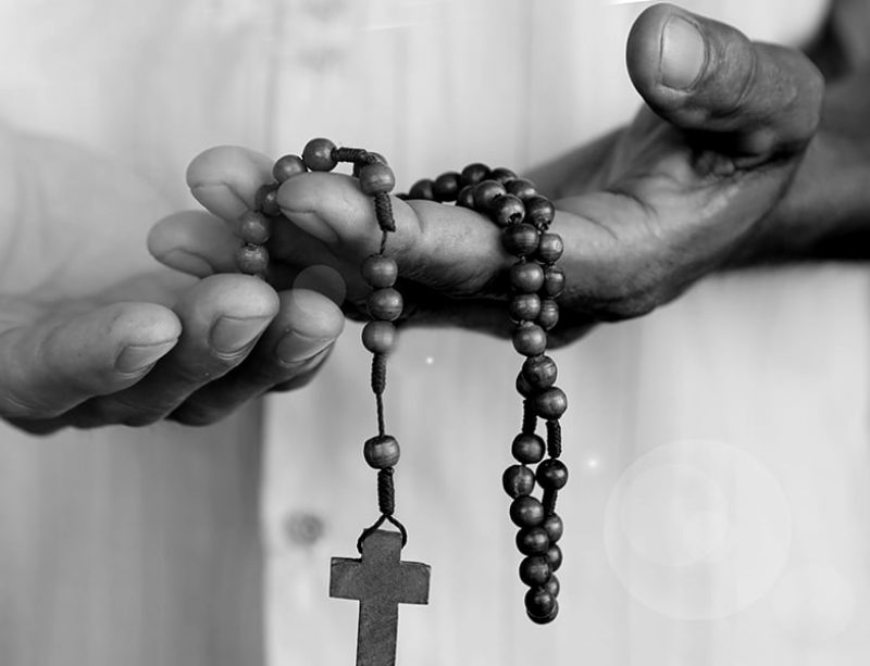 Person holding rosary beads