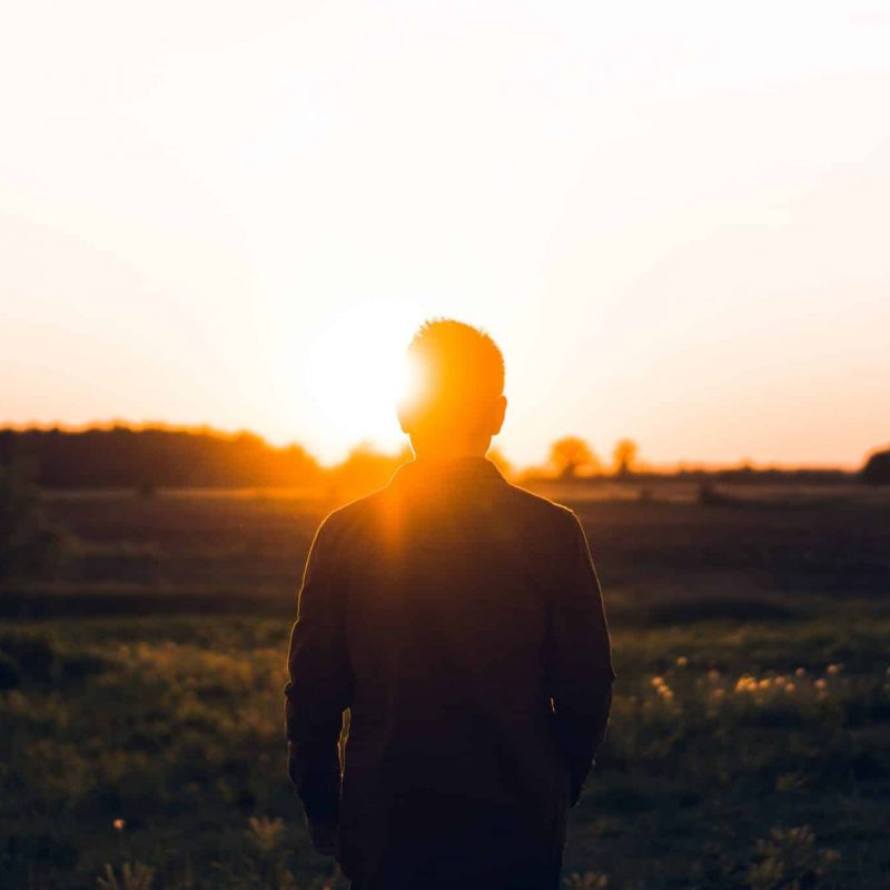 Man looking at the sunset | Photo by Warren on Unsplash