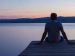 Man sitting at the endo of pier