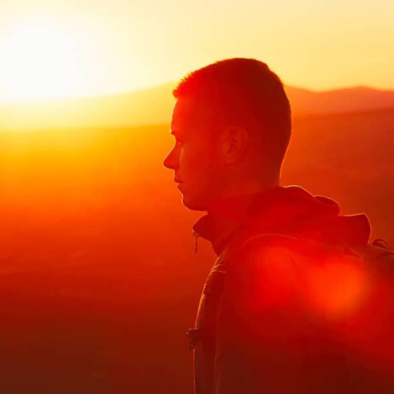 Young man bathed in sunlight walking