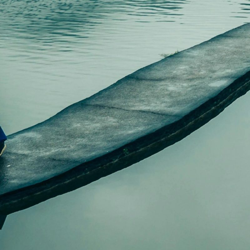 man walking over bridge surrounded by water