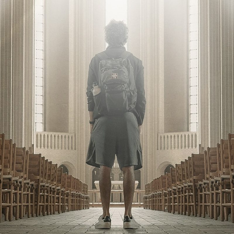 man standing in cathedral surrounded by light.
