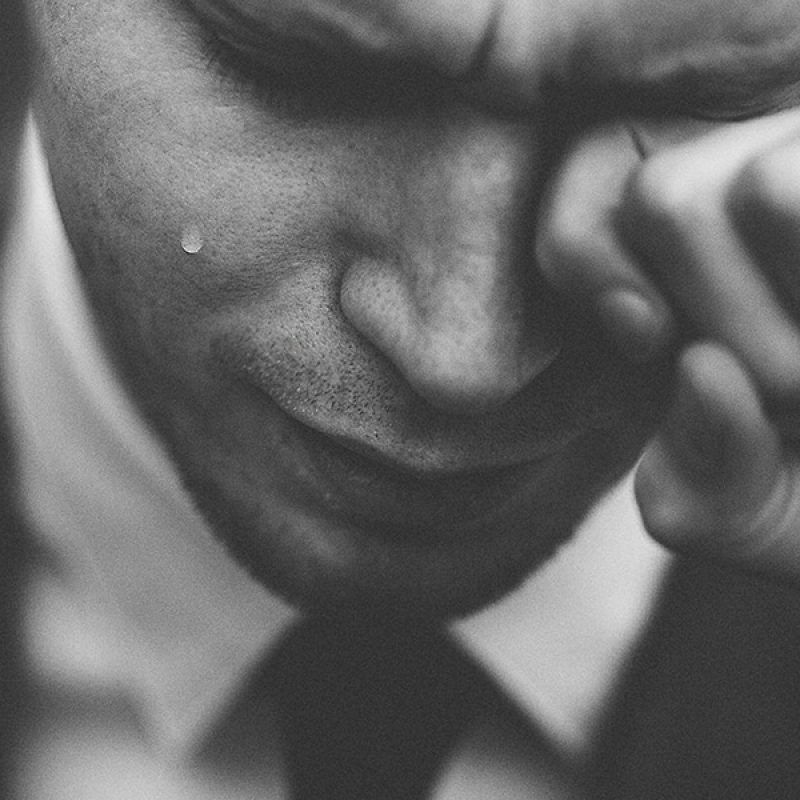 man crying in pain from emotional wounds