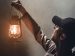 man holding a lantern, lighting up the room