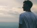 man standing on the mountain and looking into the distance