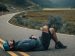 man laying down on road, looking up to the sky.